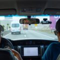 A close-up view of a dash cam mounted on a car windshield, capturing the road ahead, highlighting the importance of the best dash cams for safety.