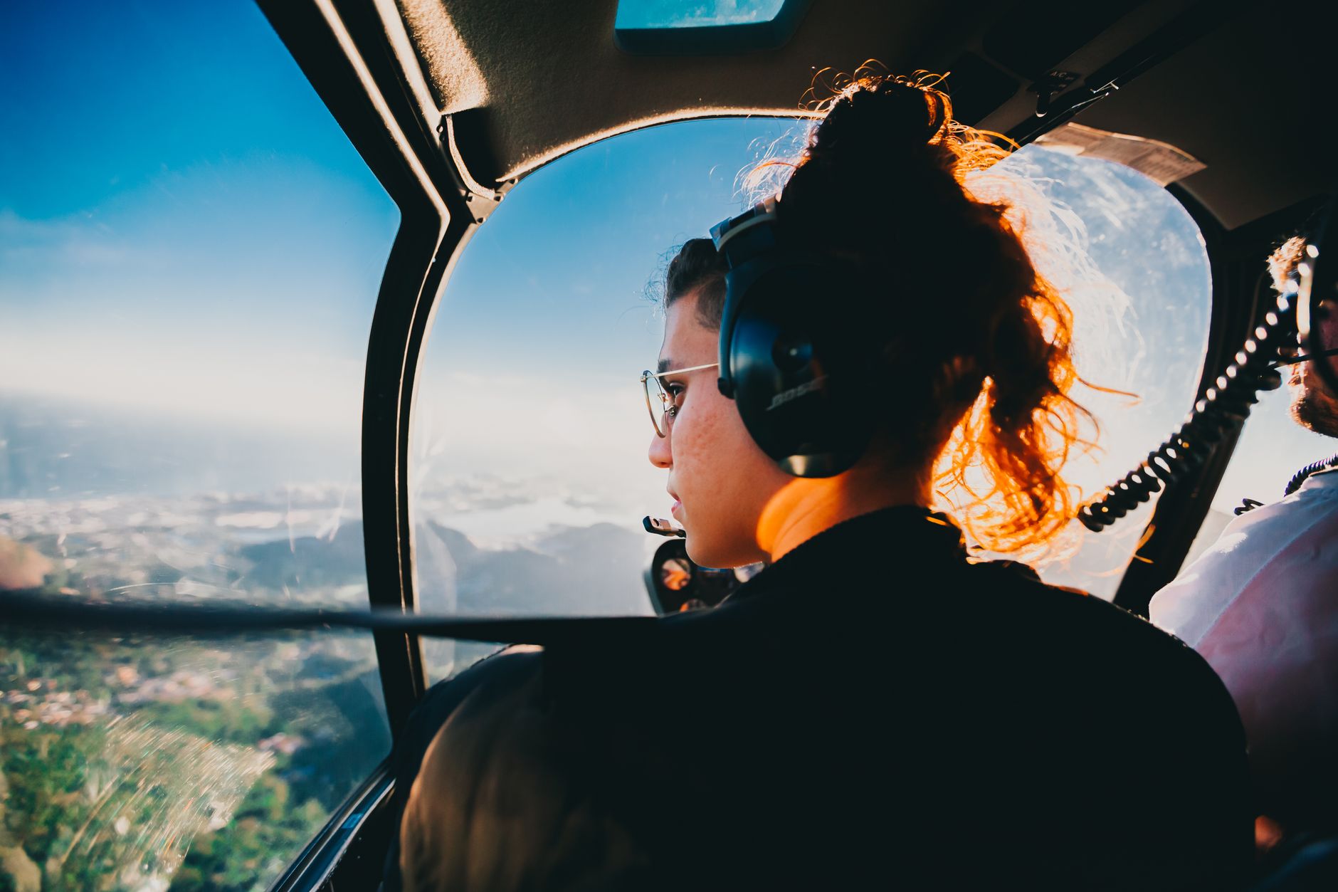 Tune Out the World: Best Noise Cancelling Headphones for 2026 2 Woman enjoying music with the best noise cancelling headphones on a plane