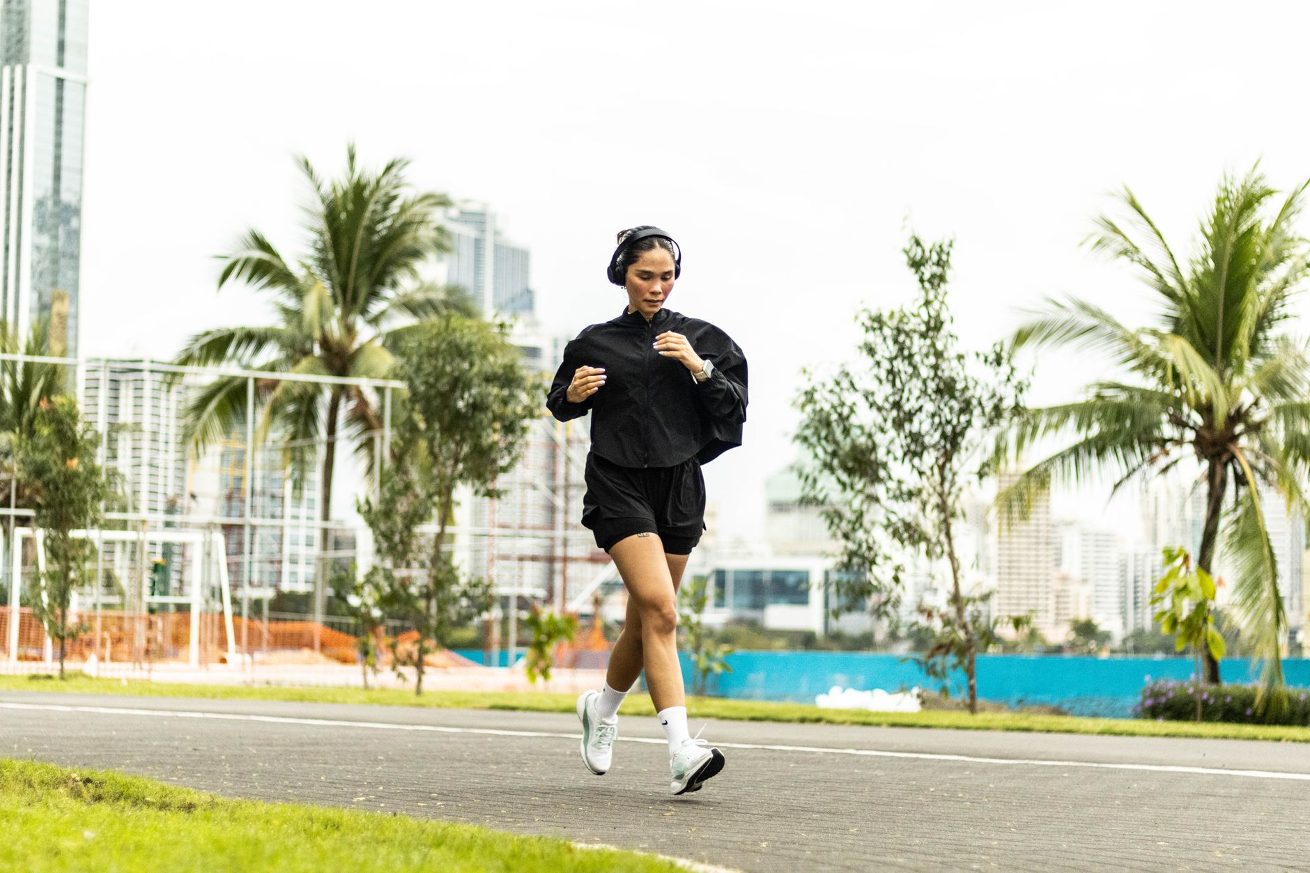 Listen Freely: The Best Open Ear Headphones for 2026 2 A person running outdoors wearing open ear headphones, staying aware of their surroundings.