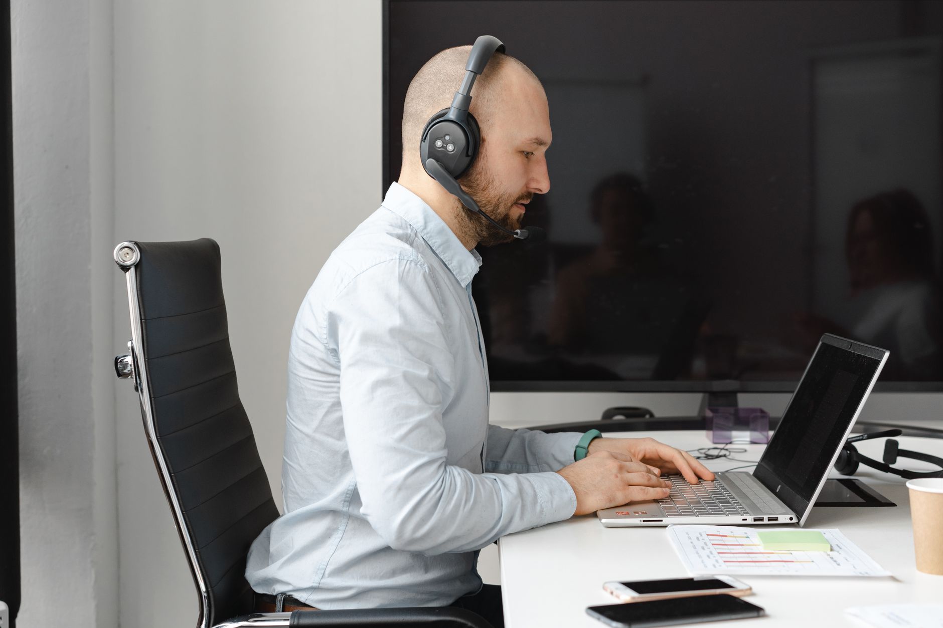 Listen Freely: The Best Open Ear Headphones for 2026 9 A person working at a desk, wearing comfortable open-ear headphones for long sessions.