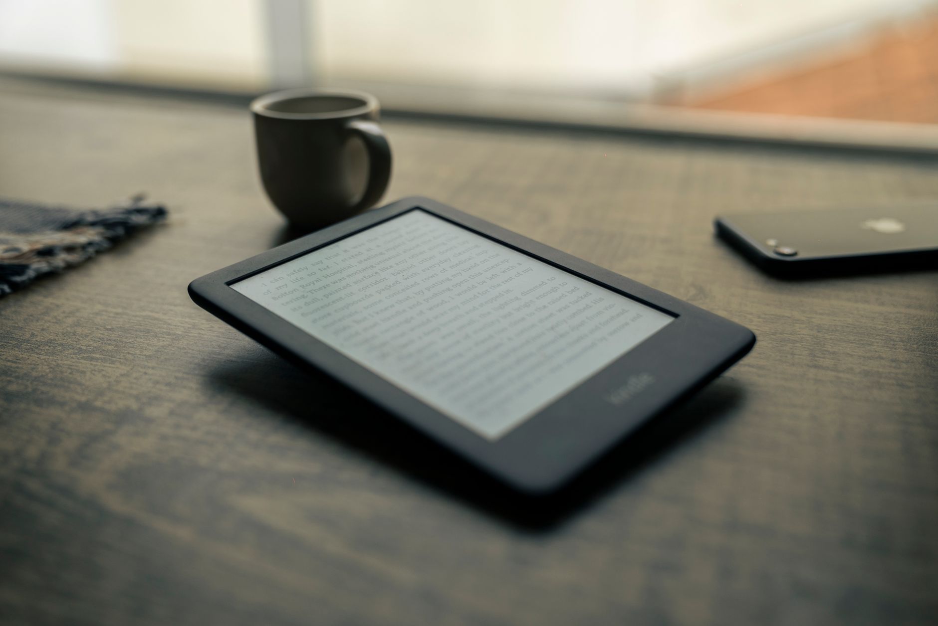 E-Reader vs Kindle: Which Device Fits Your Reading Style? 2 Side by side comparison of e-reader vs kindle on a wooden table