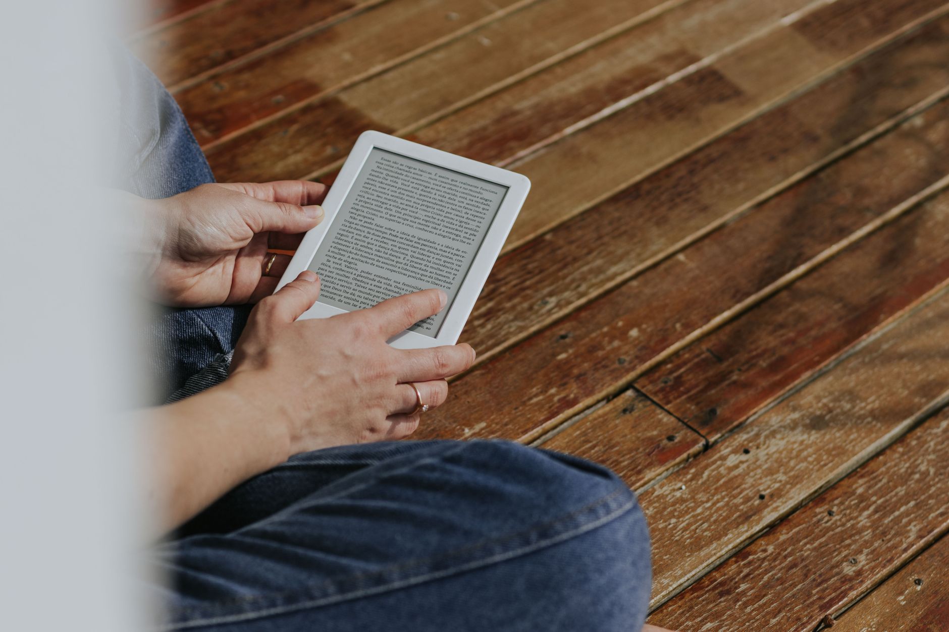 E-Reader vs. Tablet: Which Should You Buy? 3 A person comfortably reading on an e-reader in a relaxed setting.