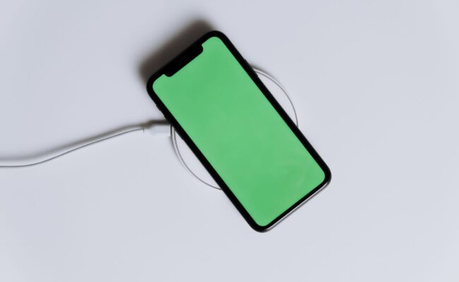 How to Fix a Wireless Charger That Stopped Working 4 Hands setting phone down to fix a wireless charger on a desk