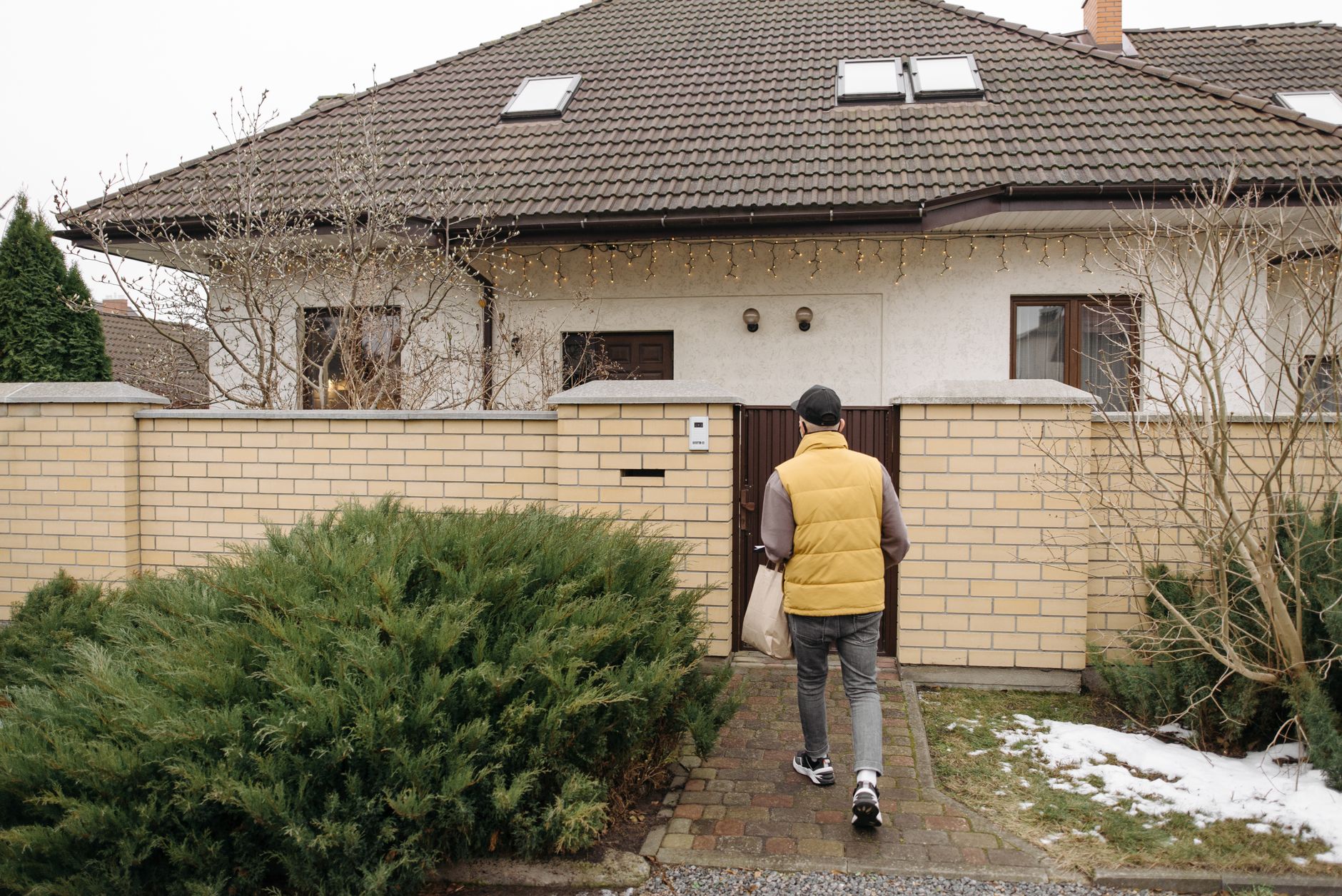 A person standing at a front door with a ring doorbell vs security camera visible