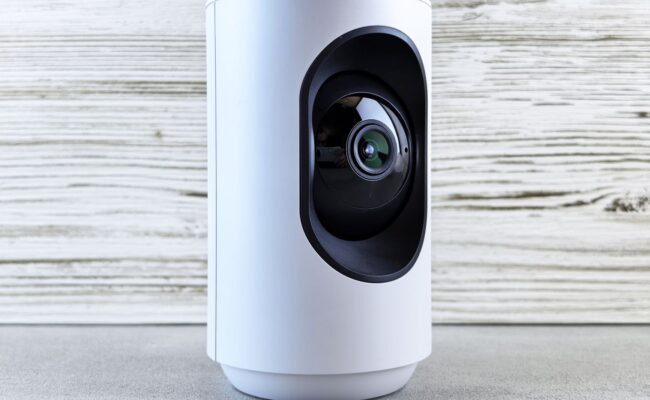 Ring Doorbell vs. Security Camera: Which Should You Buy? 2 A person standing at a front door with a ring doorbell vs security camera visible