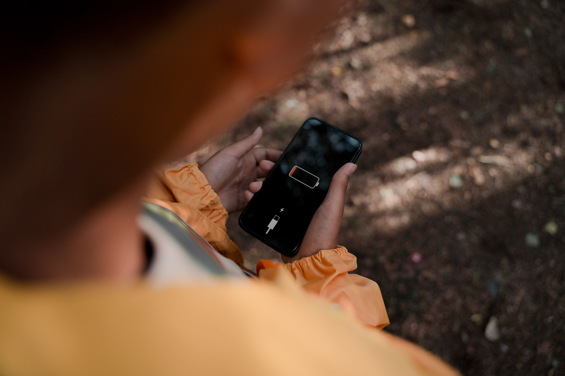 Power Bank vs Power Station: Which Should You Buy? 2 Person using a power bank to charge smartphone in outdoor setting demonstrating portable power solution for power bank vs power station